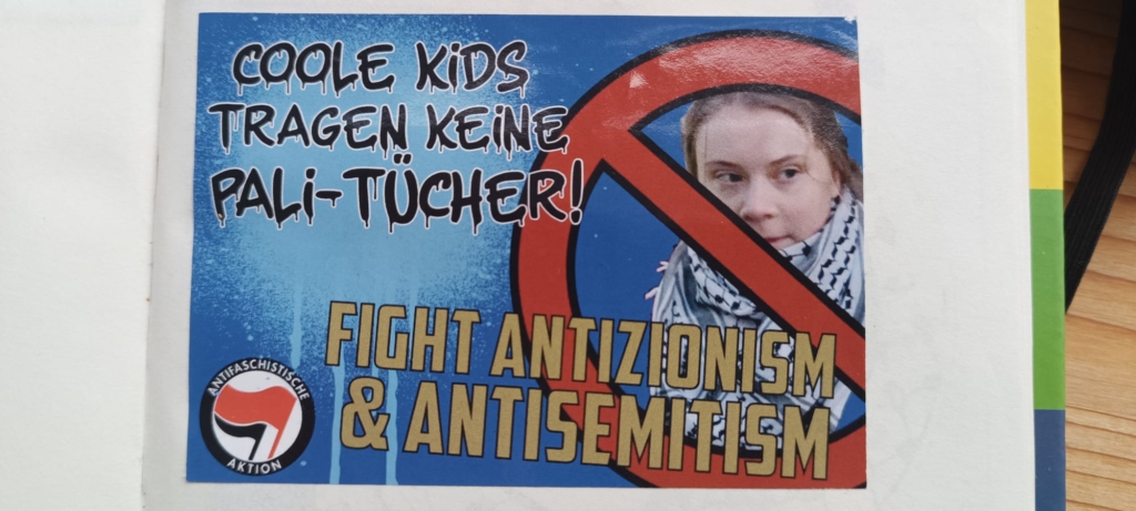 Swedish climate activist Greta Thunberg wearing a black-and-white kaffiyeh. “Cool kids don’t wear Pali scarves! Fight antizionism & antisemitism.”